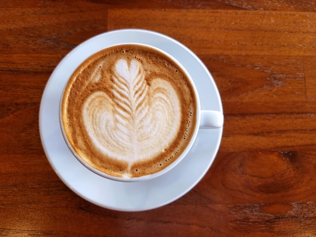 Sideway shop koffie een kopje hete latte art koffie op houten achtergrond