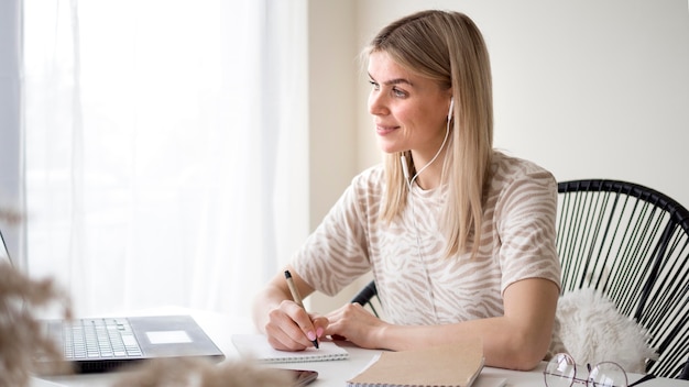 Studente carino lateralmente che prende appunti