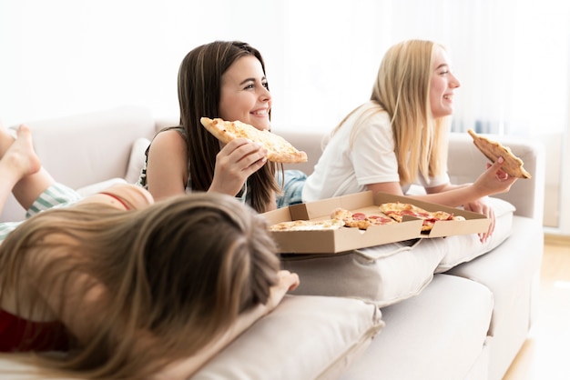 写真 ピザを食べている友人の横向きのグループ