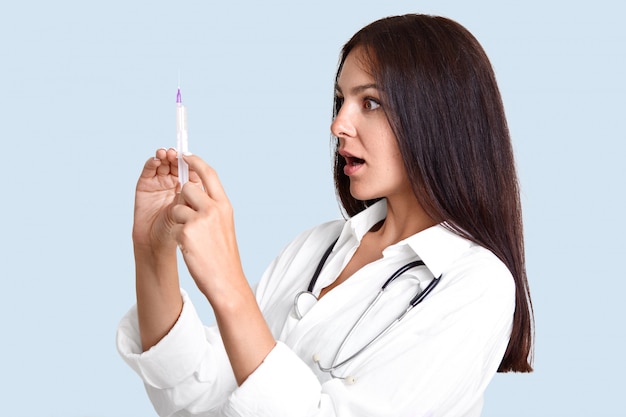 Sideways shot of female physician holds syringe