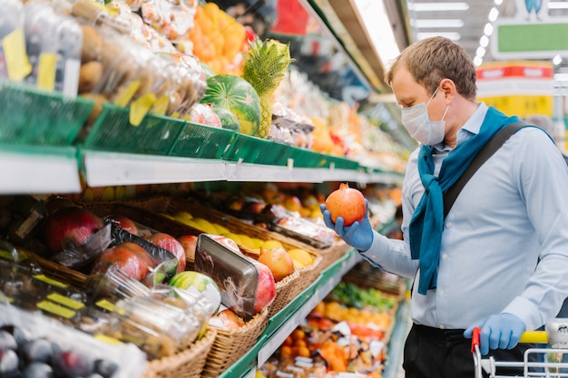 Sideways shot of man chooses fresh fruit to increase immunity during coronavirus outbreak