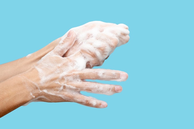 Photo sideways woman washing her hands on blue background with copy space