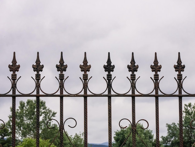 Sier metalen hek met spikes die naar boven wijzen en verschillende decoraties beschermen