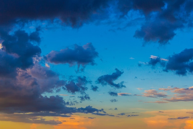 Sierlijke onregelmatige bleke zalm roze en gouden gele wolken bij zonsondergangachtergrond