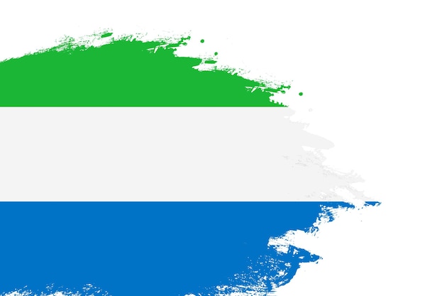Флаг Сьерра-Леоне на окрашенной кисти, нарисованной на белом фоне с копировальным пространством