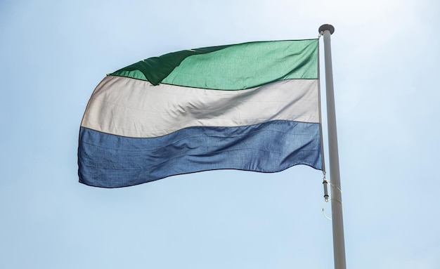 Sierra Leone flag waving against clear blue sky