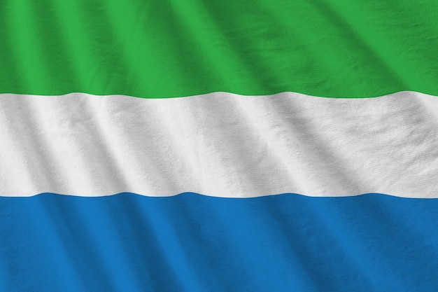 Sierra leone flag with big folds waving close up under the studio light indoors the official symbols