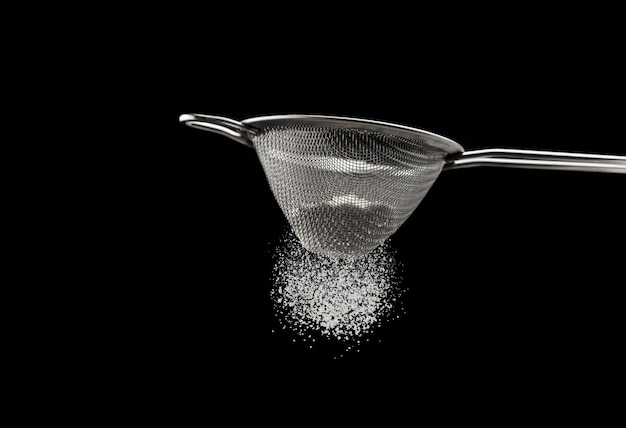 Photo sifting flour through a sieve