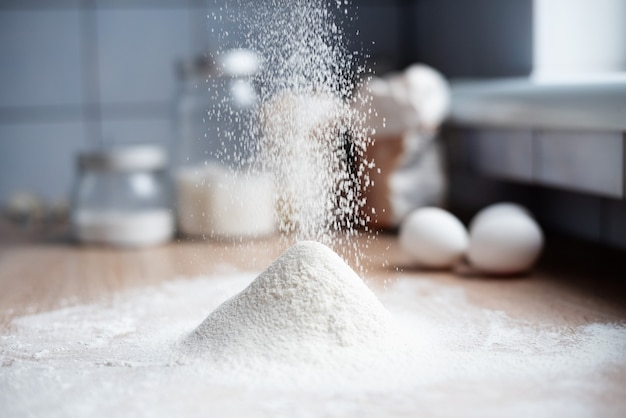 Sifting wheat flour in the kitchen with a sieve