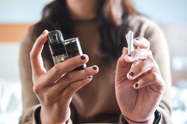 Sigaret versus e-sigaretconcept. vrouw met sigaret en vape. beste voor achtergrond in de gezondheidszorg