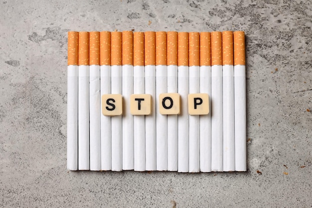 Sigaretten op een rij gerangschikt met het woord Stop Stop met roken geen tabaksdagconcept