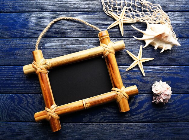 Sign board with shell and sea stars on wooden background