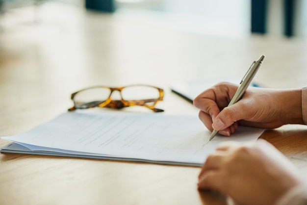 Sign on the dotted line Closeup shot of an unidentifiable businesswoman filling in paperwork in an office