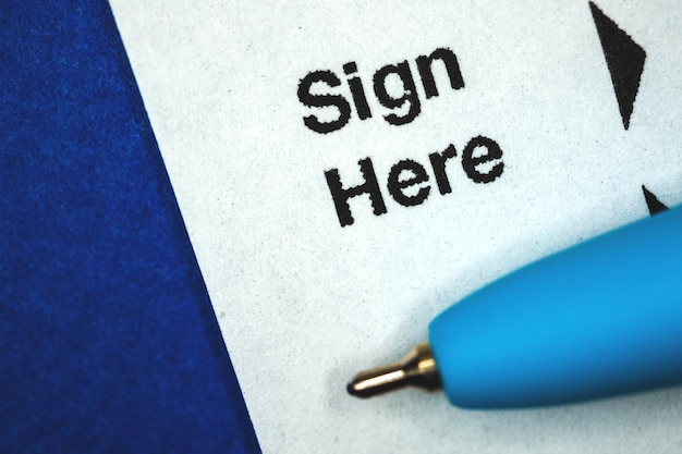 Sign here, signature contract business concept with documents\
and pen, blue background photo