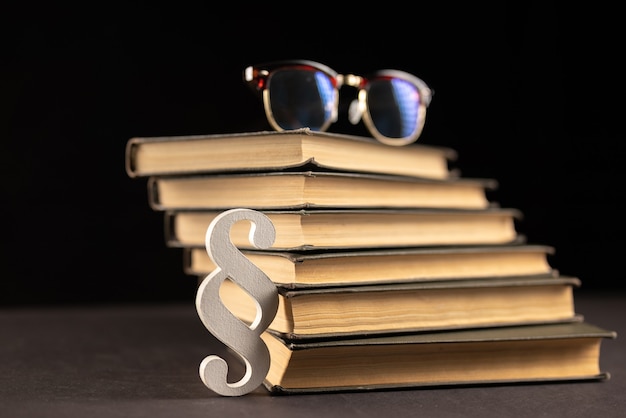 Sign paragraph glasses and books on black stone background