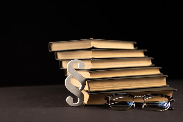 Sign paragraph glasses and books on black stone background