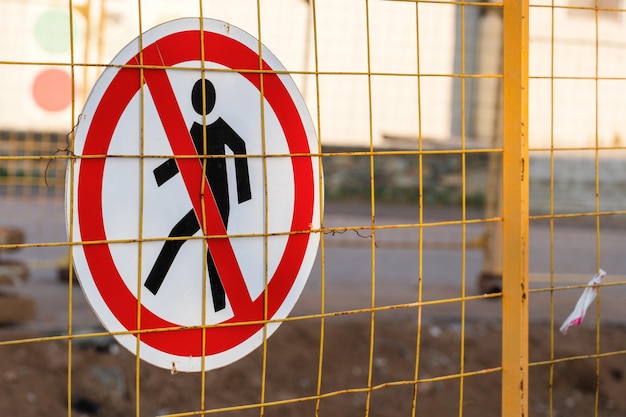 The sign passage is prohibited hangs on the grid of the fence of the construction site