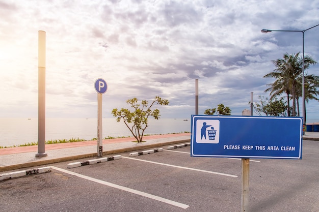 Sign post warning about keep clean at car park beside beach