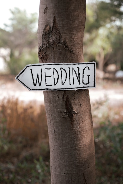 Foto un cartello su un albero che indica il luogo del matrimonio