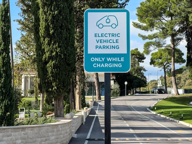 Sign with the inscription and the symbol of the car on a pole by the road in the park caption