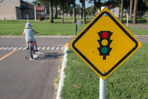 Photo a sign with traffic lights against a background of a child on a bike great for safety messages