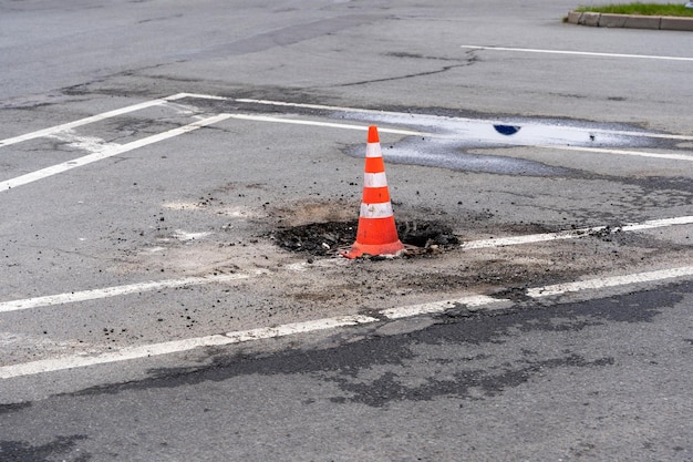 Signaal verkeerskegel op een defect rioolmangat op een stadsweg