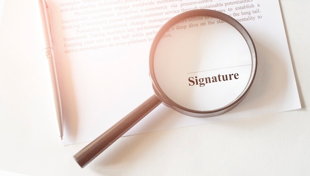 Signaure line in contract with pen and magnifying glass