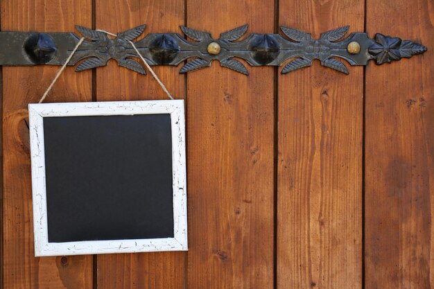 Photo signboard hanging on wooden fence