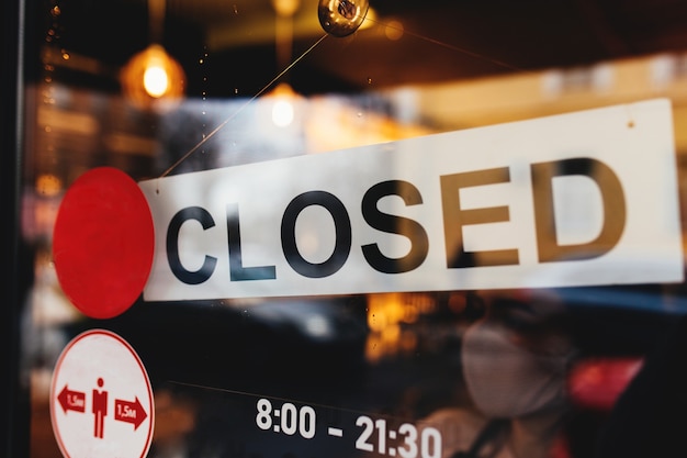 Signboard with Closed text at the cafe through glass window