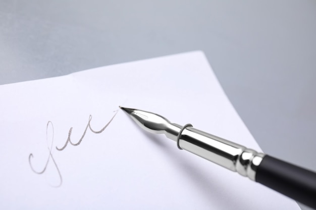Фото Подпись на листе бумаги перьевой ручкой на светло-сером фоне крупным планом пространство для текста