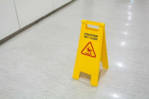 Signs plastic yellow put on floor text caution wet floor in hospital