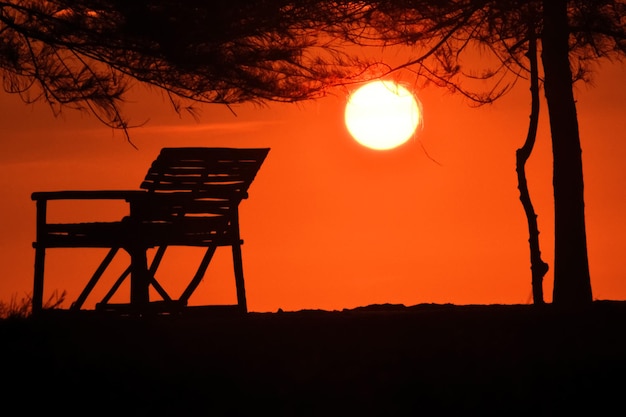 Sihouette of Chair in the beach on sunset sky