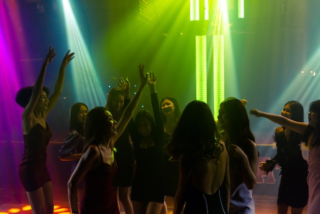 Silhouet afbeelding van mensen dansen in disco nachtclub op muziek van Dj op het podium