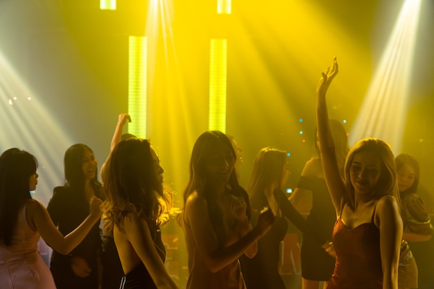 Silhouet afbeelding van mensen dansen in disco nachtclub op muziek van Dj op het podium