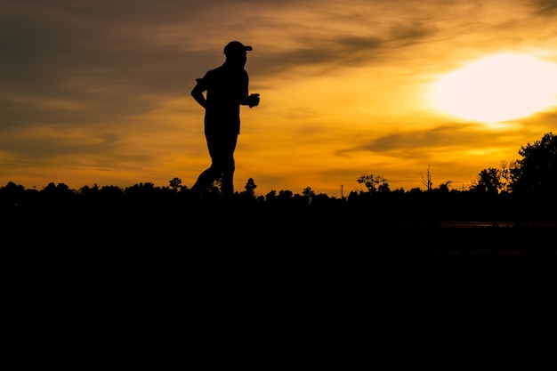 Silhouet een mens die voor oefening bij zonsondergang aanstoot.