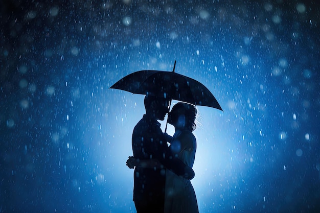 Silhouet een paar staande onder een paraplu in de regen