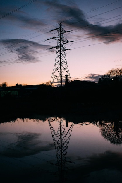 Silhouet elektriciteitspylon bij het meer tegen de hemel bij zonsondergang