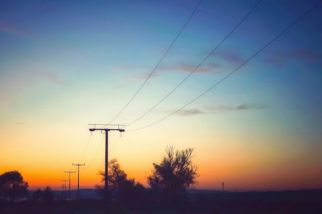 Silhouet elektriciteitspylon tegen de romantische hemel bij zonsondergang