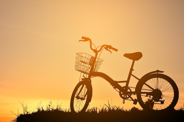 Silhouet fiets op de berg tegen een heldere lucht tijdens de zonsondergang