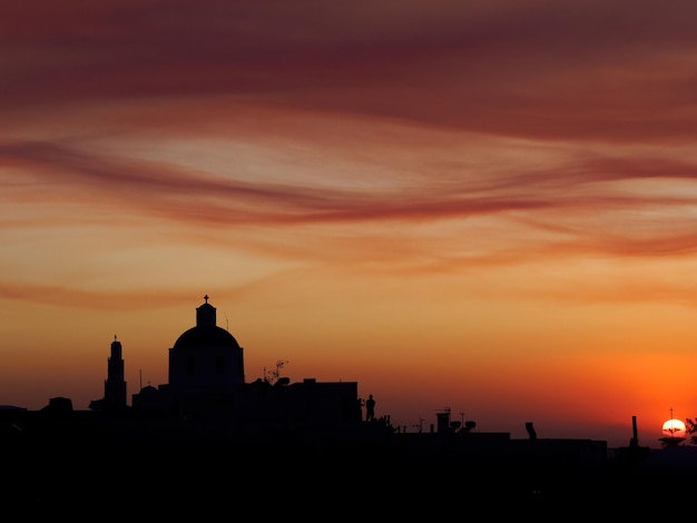 Silhouet gebouwen tegen de hemel tijdens zonsondergang