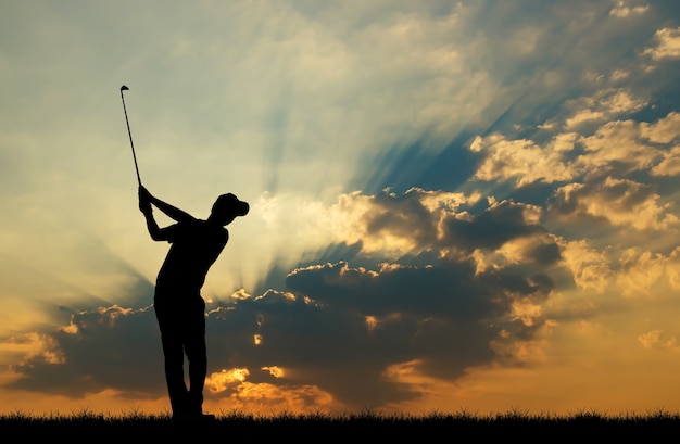 Foto silhouet golfer golfen tijdens prachtige zonsondergang