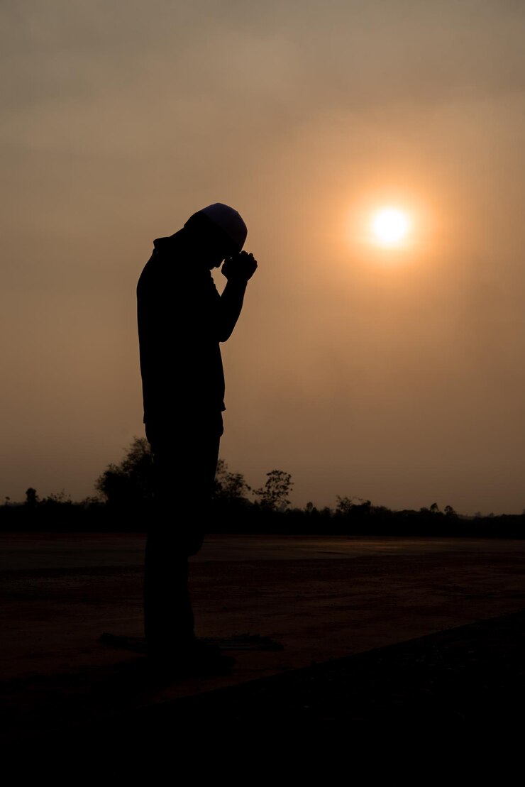 Silhouet jonge Aziatische moslim man bidden op sunsetRamadan festival concept