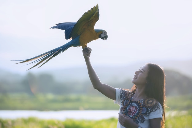 Silhouet jonge vrouw met grappige kleurrijke papegaai