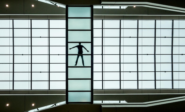 Silhouet man die bij het raam staat