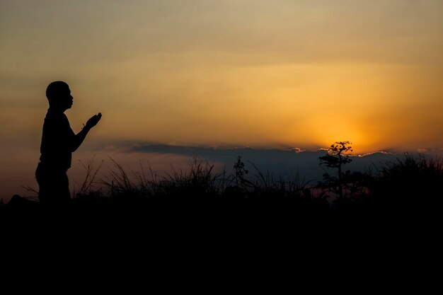 Foto silhouet man die tegen de hemel staat bij zonsondergang