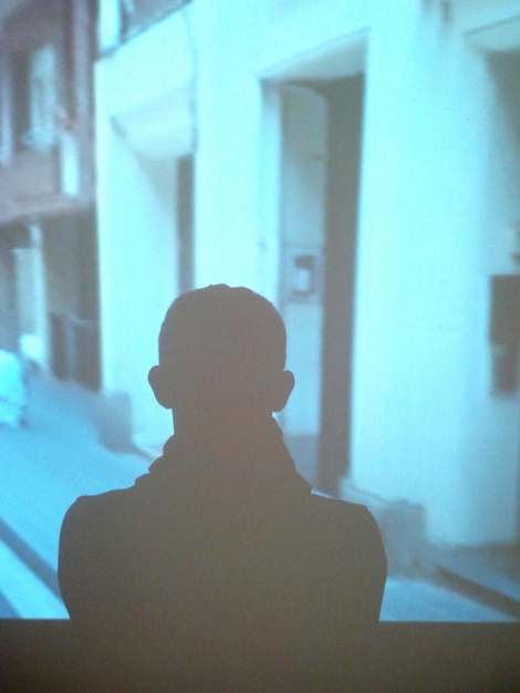 Foto silhouet man die voor het projectiescherm staat