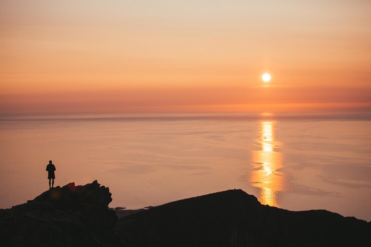 Foto silhouet man kijkt naar de zee tegen de hemel tijdens zonsondergang