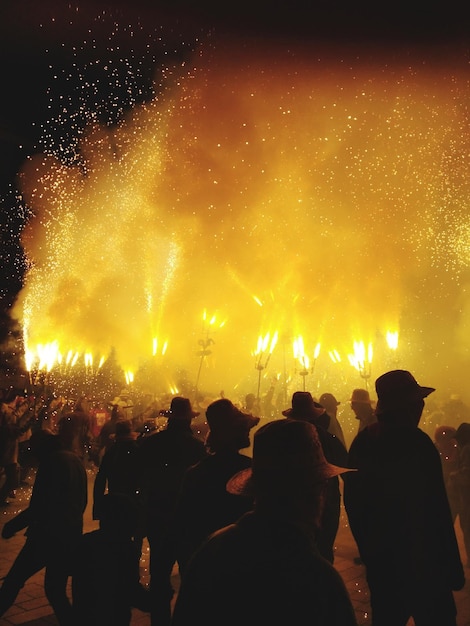 Silhouet mensen die 's nachts naar vuurwerk kijken