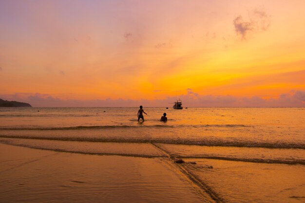 Foto silhouet mensen op het strand tegen de hemel tijdens de zonsondergang