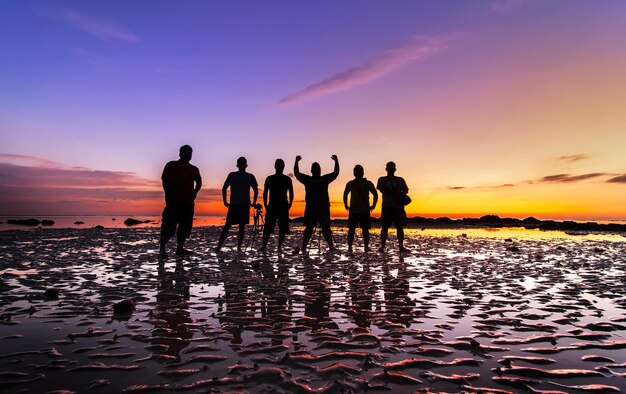 Foto silhouet mensen op het strand tegen de hemel tijdens de zonsondergang